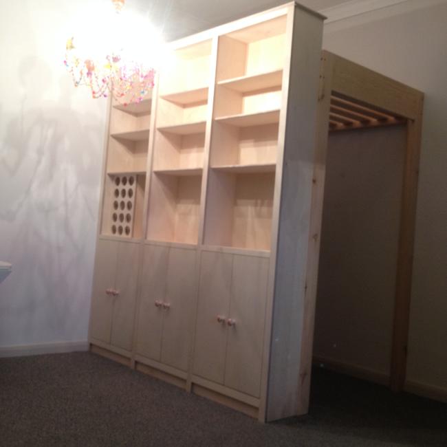 cabinetry for one room living.mezzanine bed creating private study space beneath