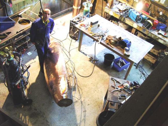 Michael Chaikin in studio with giant verdigris pot in early stages of construction