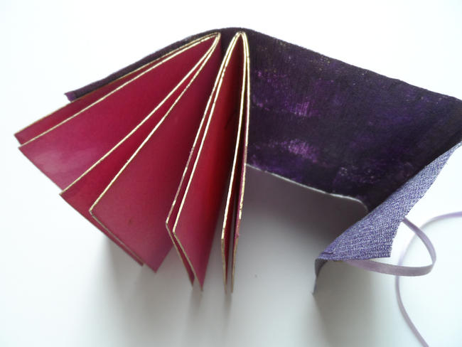 Handmade paper cloth cover, pamphlet stitch binding, hand coloured pages, ribbon close