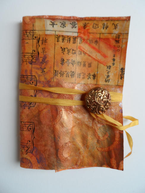 Handmade paper cloth cover, pamphlet stitch binding, ribbon and button close