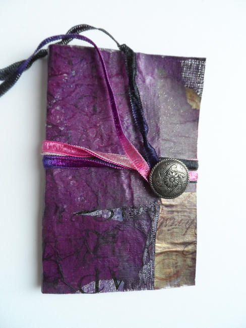 Handmade paper cloth cover, pamphlet stitch binding, ribbon and button close