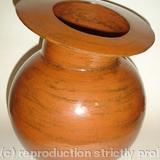 Stoneware pot with spherical body and tilted rim.