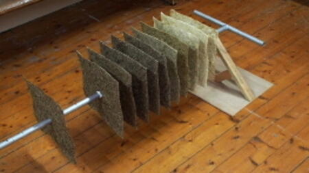 Assembly of paper squares on to peat coring rod prior to installation at Brantwood.