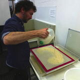 Pouring out the pulp to make a paper cloud on the mesh screen. paper Studio Northumbria, Northumbria University