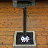 Sharp end of 4.5m  peat coring road suspended over the image of the birch pollen set in unbleached grass paper stained with peat water.