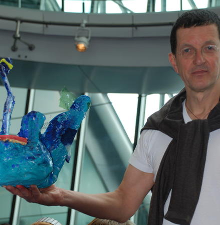 Antony Gormely holding the winning sculpture as created by Berrin's pupils at Drayton Park Primary School.