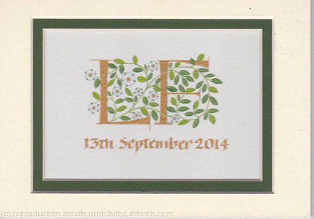 Two letters in gold with white roses and green leaves