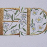 Two 23c gold leaf letters with wild garlic and mountain avens flowers.