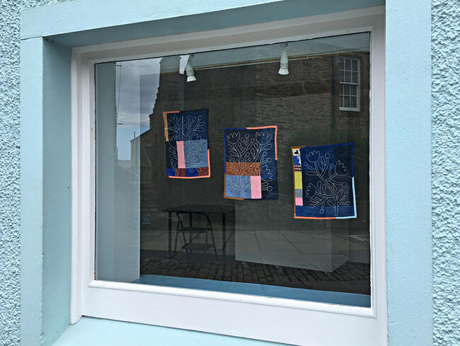 Window with wall hangings by Amy Blackwell