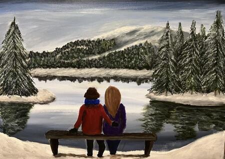 Couple sat next to a lake in winter  