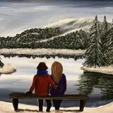 Couple sat next to a lake in winter  